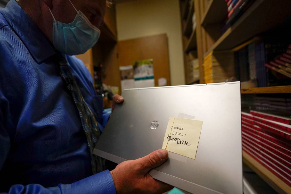 Tom Baumgarten, superintendent of the Morongo County School District, looks at a laptop with a ...