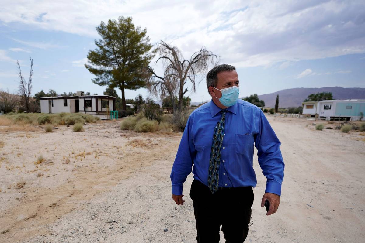Tom Baumgarten, superintendent of the Morongo County School District, walks down a dirt road ne ...