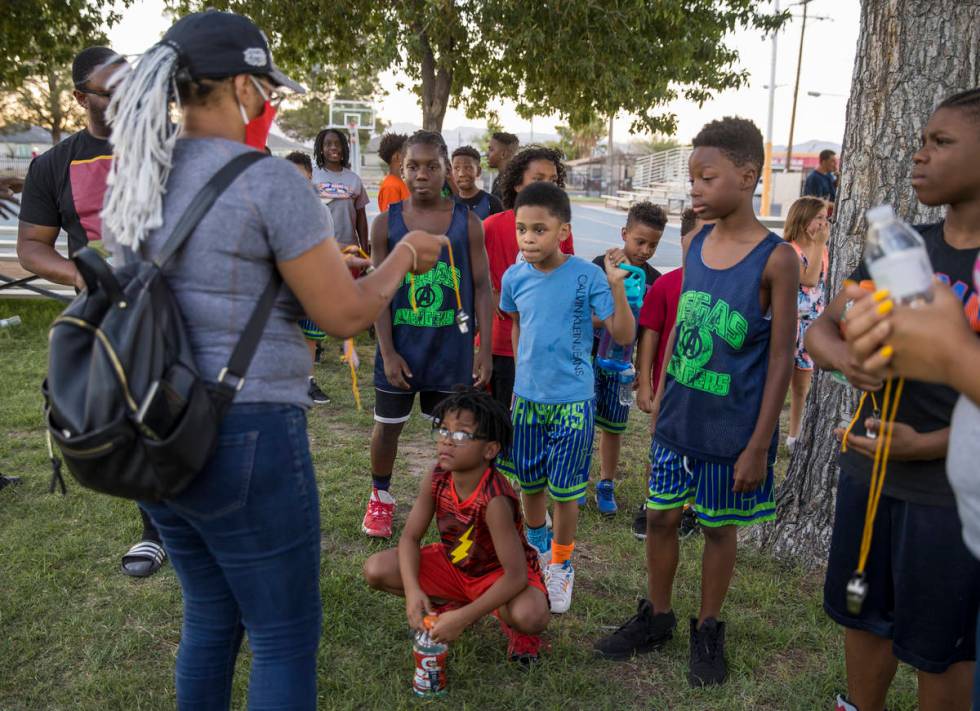 New Era Las Vegas members pass out alert whistles and face masks to children gatheredʡt K ...