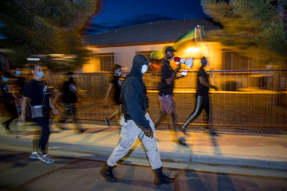 New Era Las Vegas members chant and march into the nightʡlong West Monroe Avenue on Tuesd ...