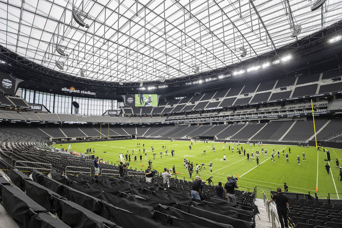 Las Vegas Raiders players and coaches take the field during NFL football training camp at Alleg ...