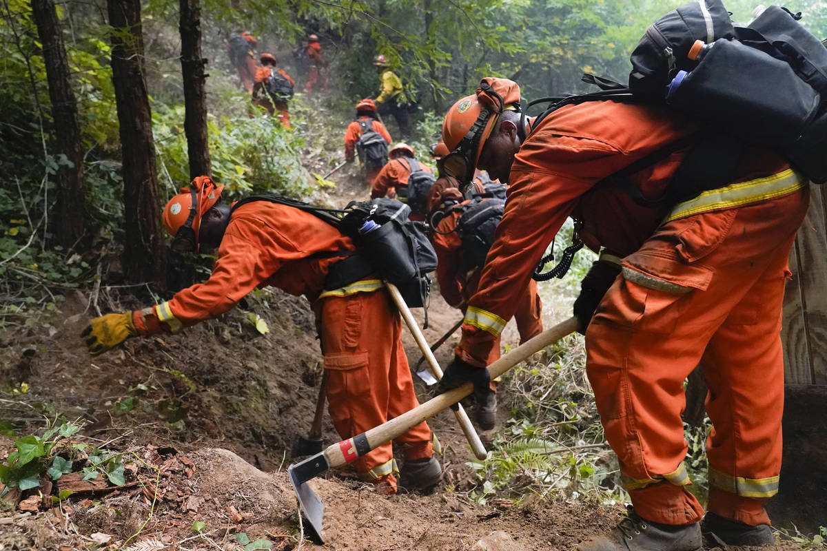 A California Department of Corrections crew builds a containment line along Highway 9 to preven ...