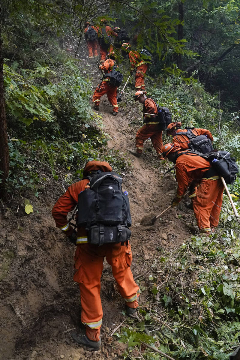 A California Department of Corrections crew builds a containment line along Highway 9 to preven ...