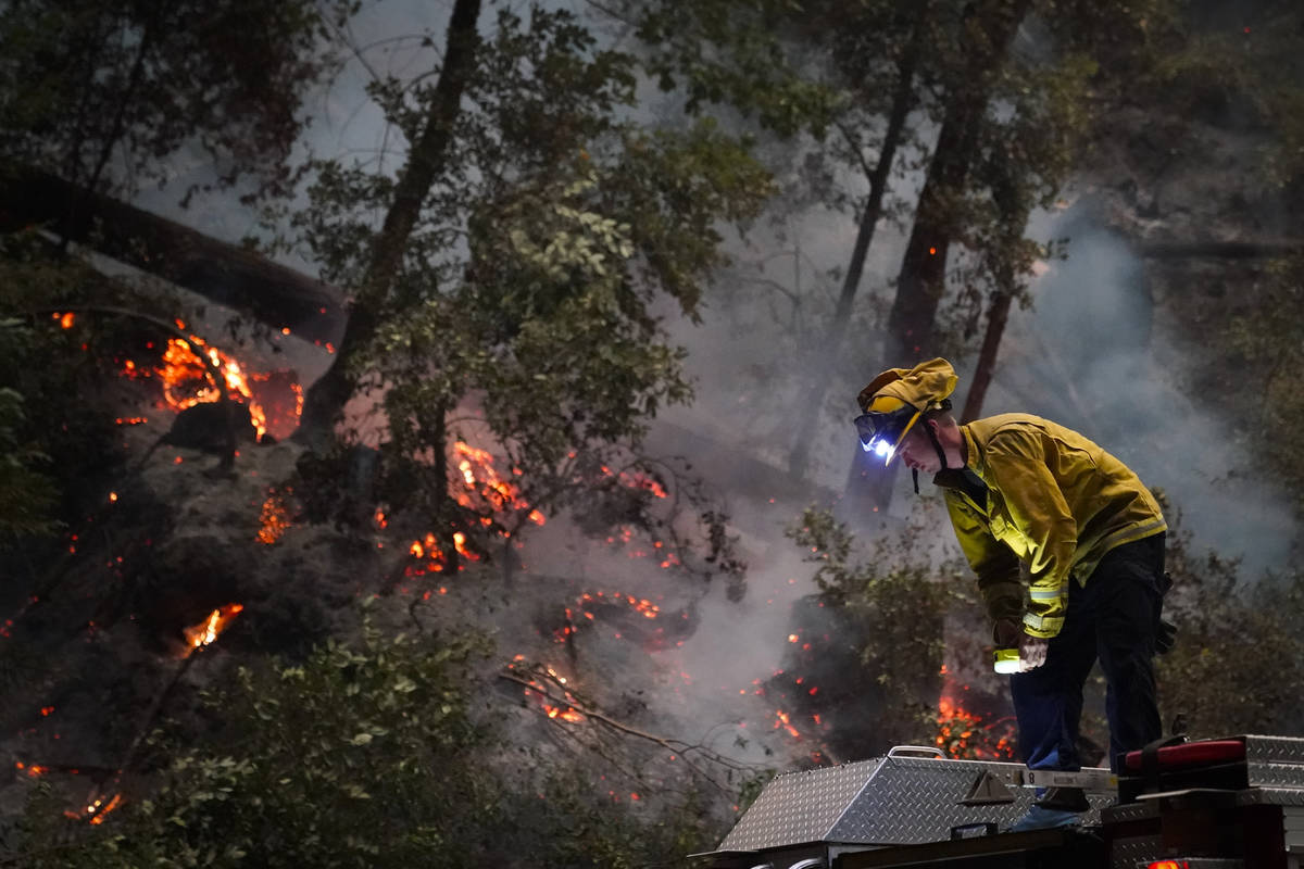 Ben Slaughter, a firefighter for the Boulder Creek Fire Department, stands on top of a fire tru ...