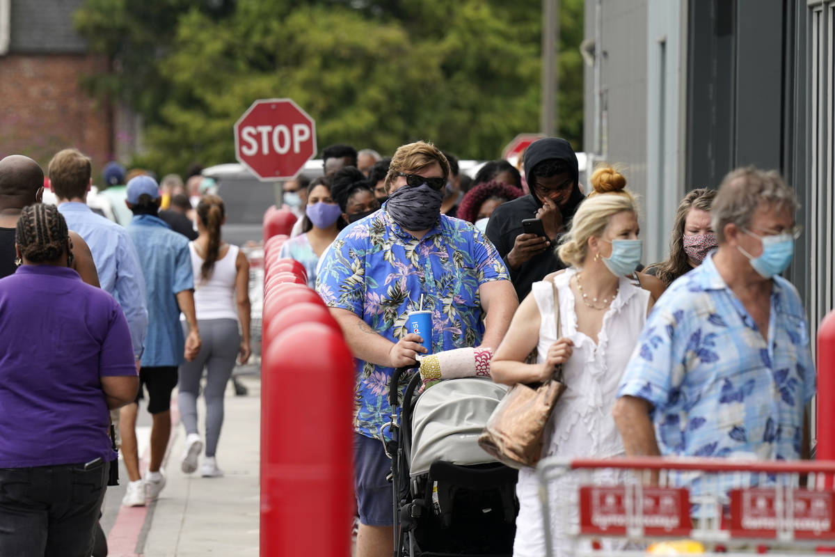 People line up to enter retail chain Costco to buy provisions in New Orleans, Sunday, Aug. 23, ...