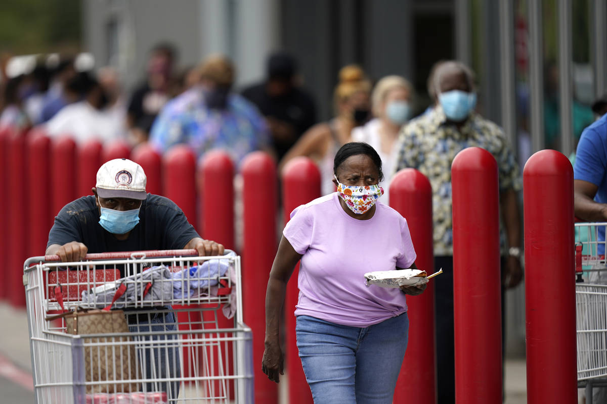People line up to enter retail chain Costco to buy provisions in New Orleans, Sunday, Aug. 23, ...