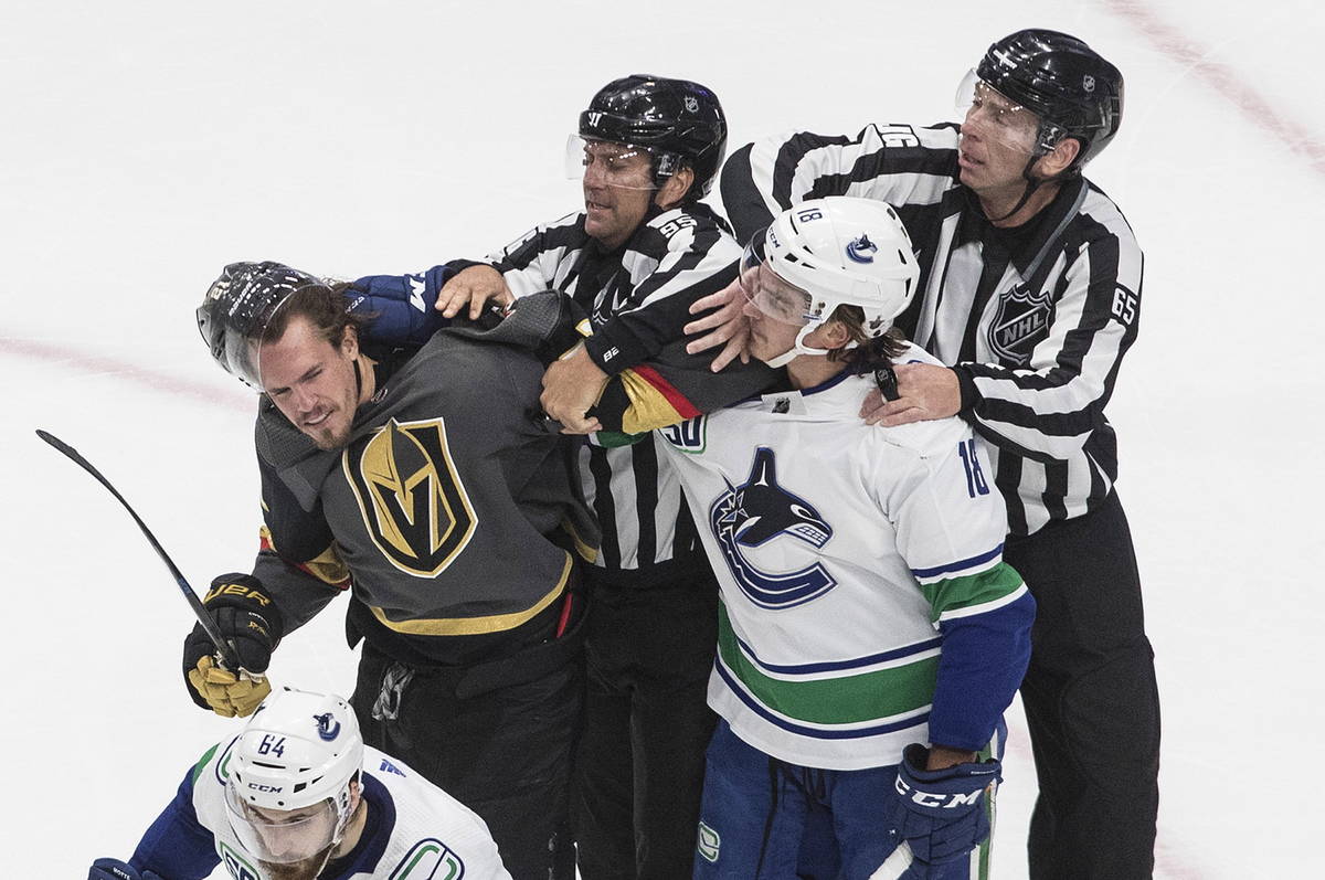 Vegas Golden Knights' Nick Cousins (21) and Vancouver Canucks' Jake Virtanen (18) rough it up d ...