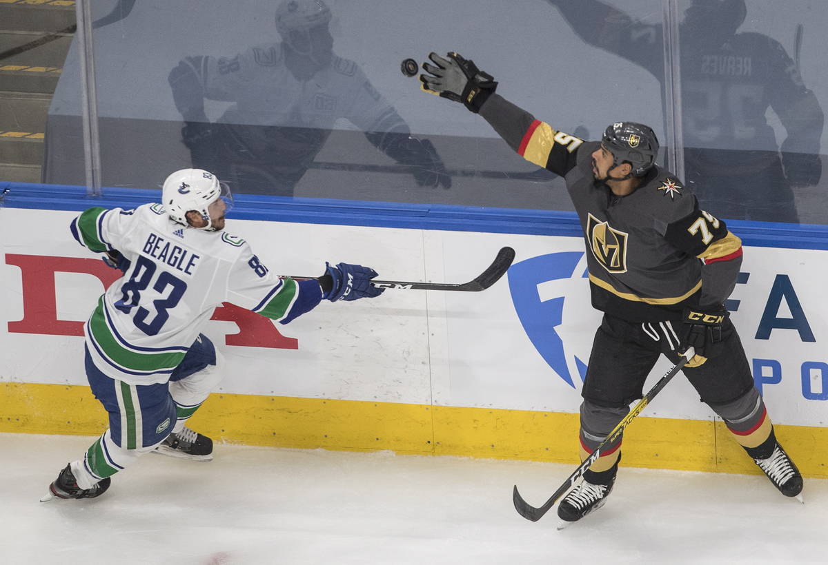 Vegas Golden Knights' Ryan Reaves (75) catches the puck as Vancouver Canucks' Jay Beagle (83) m ...