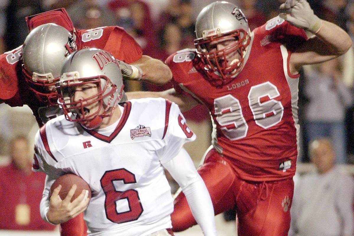 UNLV quarterback Scott Turner, center, runs from leaping New Mexico defenders Nick Speegle, lef ...