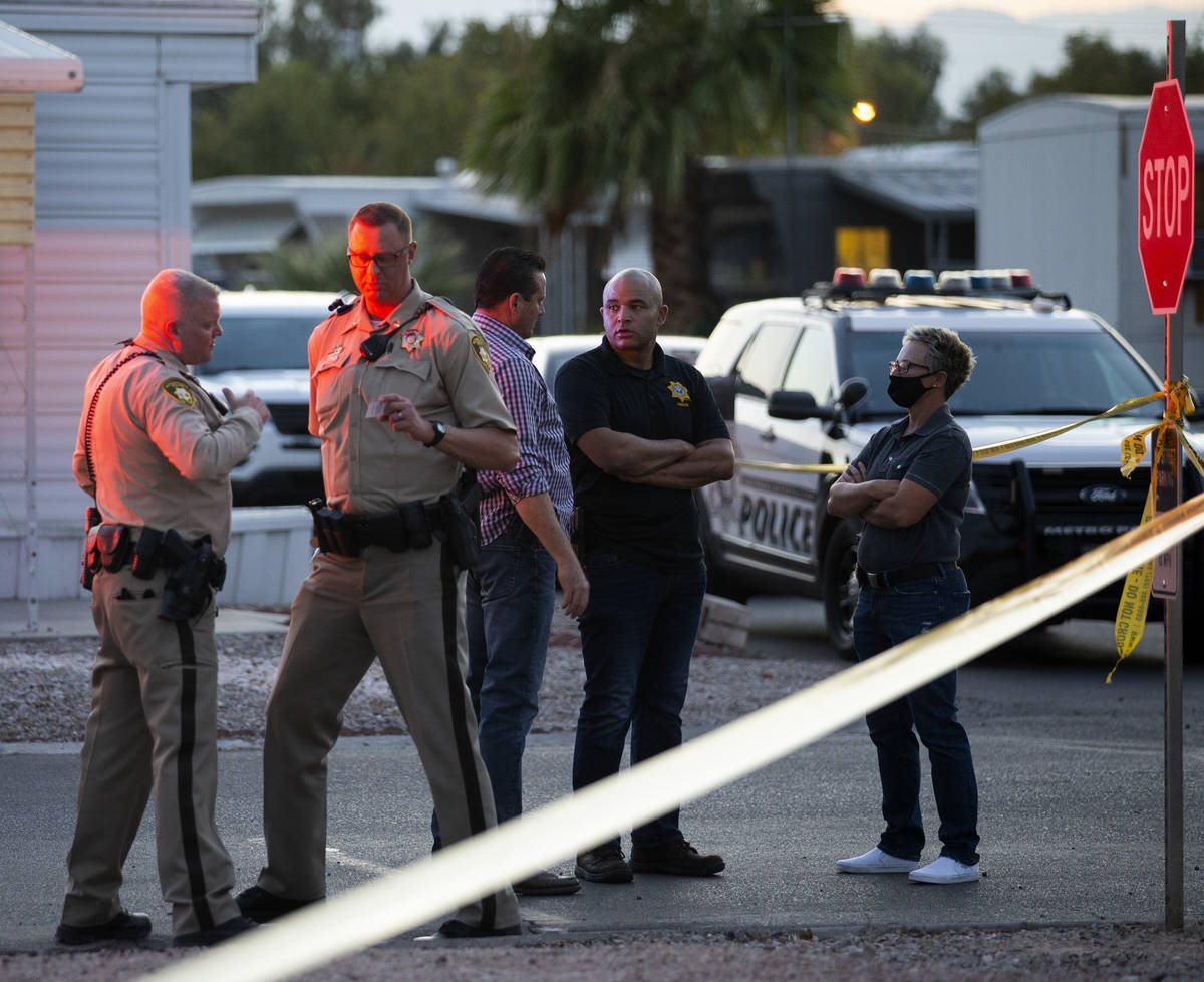 Metropolitan police, including Homicide Lt. Ray Spencer, second from right, investigate a homic ...