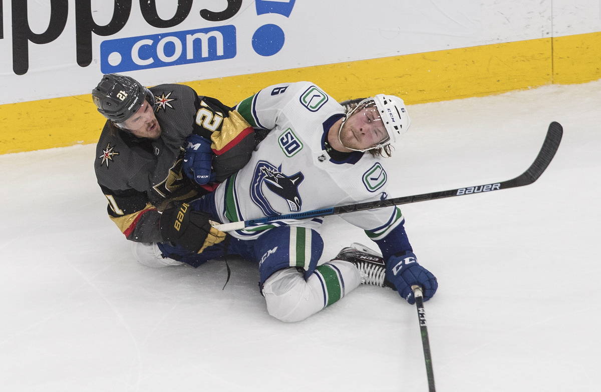 Vegas Golden Knights' Nick Cousins (21) and Vancouver Canucks' Brock Boeser (6) become entangle ...