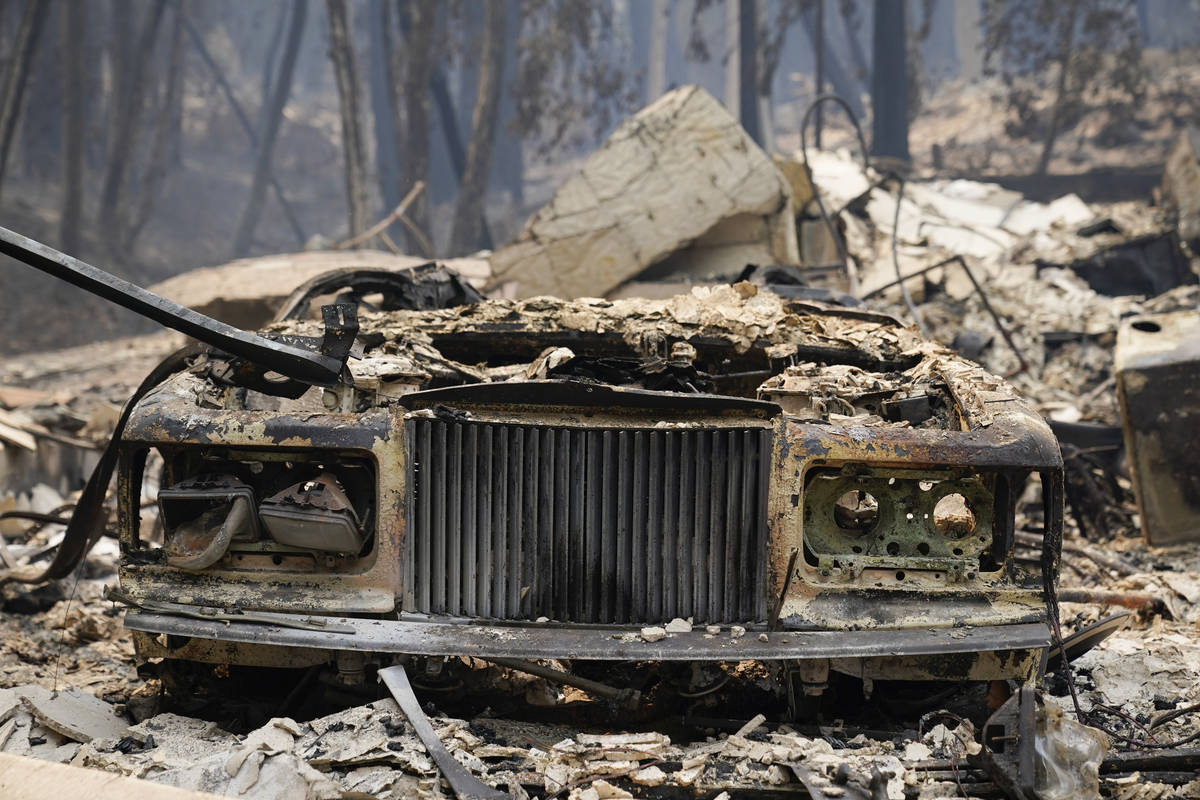 A charred vehicle is parked in front of a home after the CZU Lightning Complex Fire went throug ...