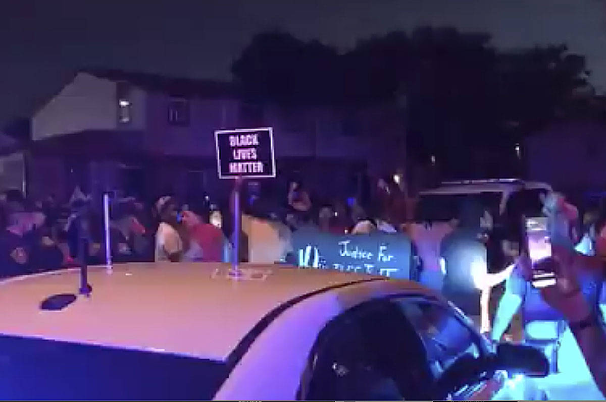 In this image made from video, protesters gather near the site of a police shooting, Sunday, Au ...