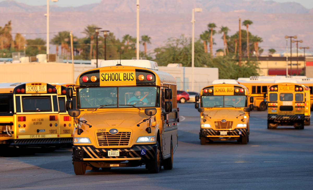 Drivers head out of the Clark County School District Arville Bus Yard in Las Vegas on the first ...