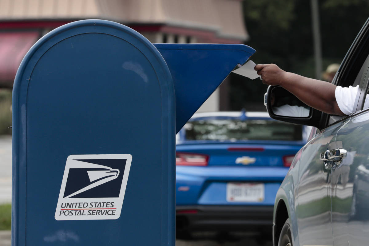 A man mails a letter on Saturday, August 22, 2020 in Whitehall, Ohio. Postal workers and suppor ...