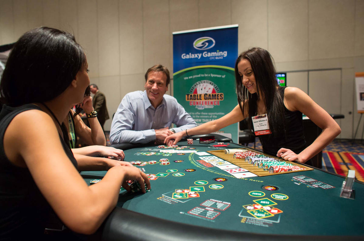 Lemon Mosissa (cq), left, Dean Barnett, center, and Laura Villanueva play High Card Flush at th ...