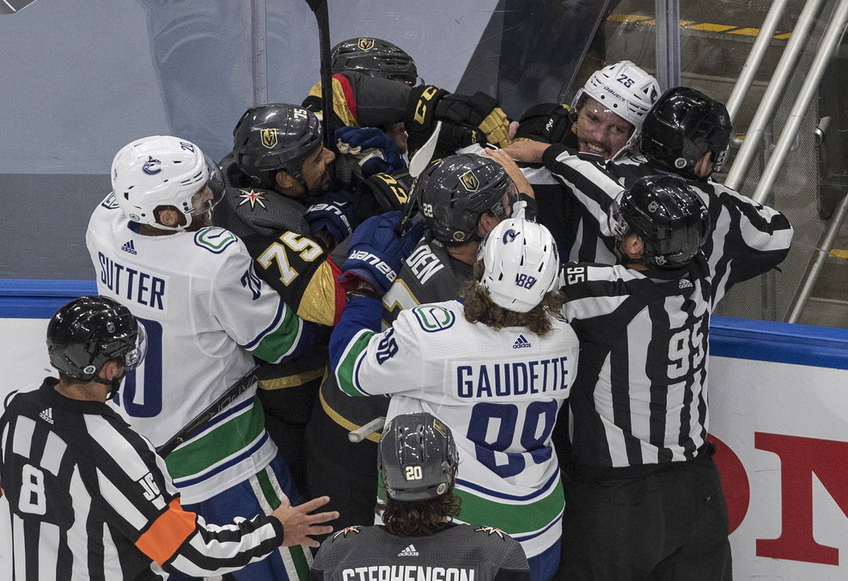 Vegas Golden Knights' Ryan Reaves (75) and Vancouver Canucks' Antoine Roussel (26) rough it up ...