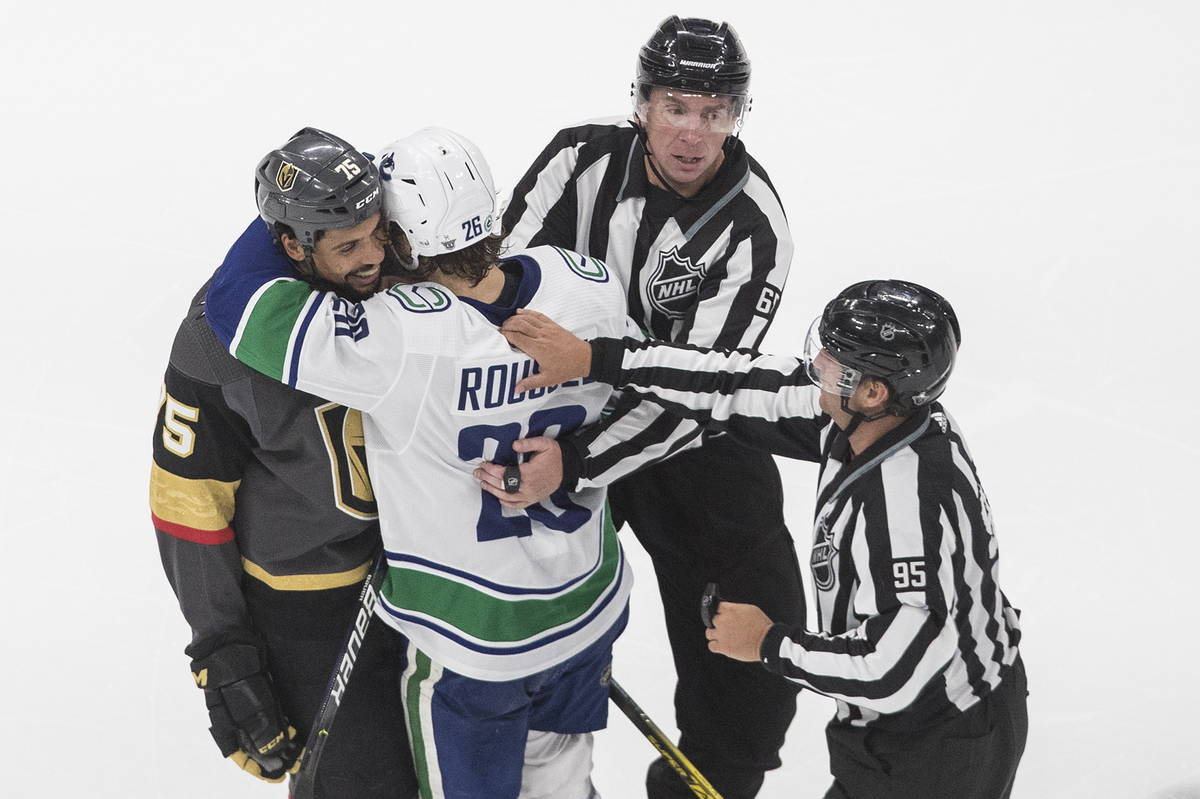 Vegas Golden Knights' Ryan Reaves (75) is hugged by Vancouver Canucks' Antoine Roussel (26) aft ...
