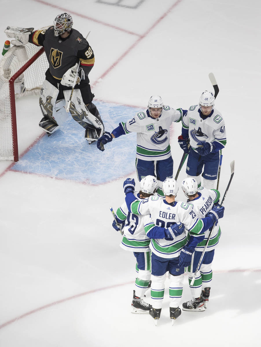 The Vancouver Canucks celebrate a goal on Vegas Golden Knights goalie Robin Lehner during the f ...