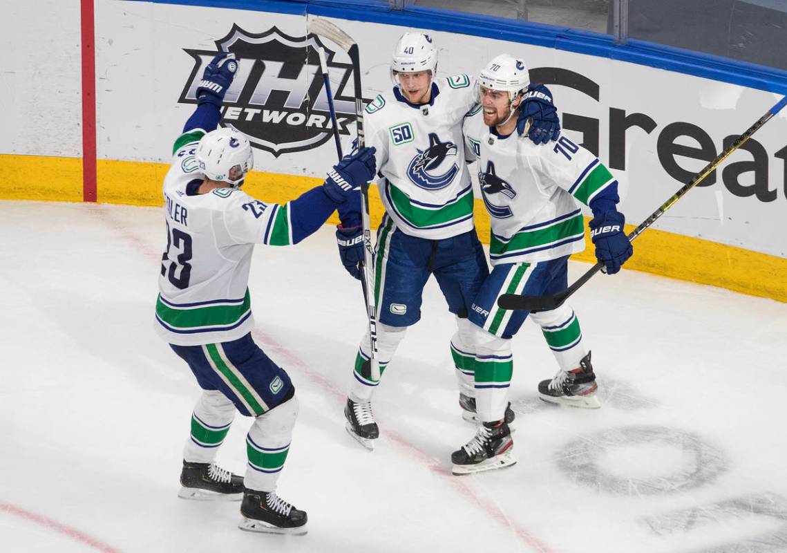Vancouver Canucks' Alexander Edler (23), Elias Pettersson (40) and Tanner Pearson (70) celebrat ...