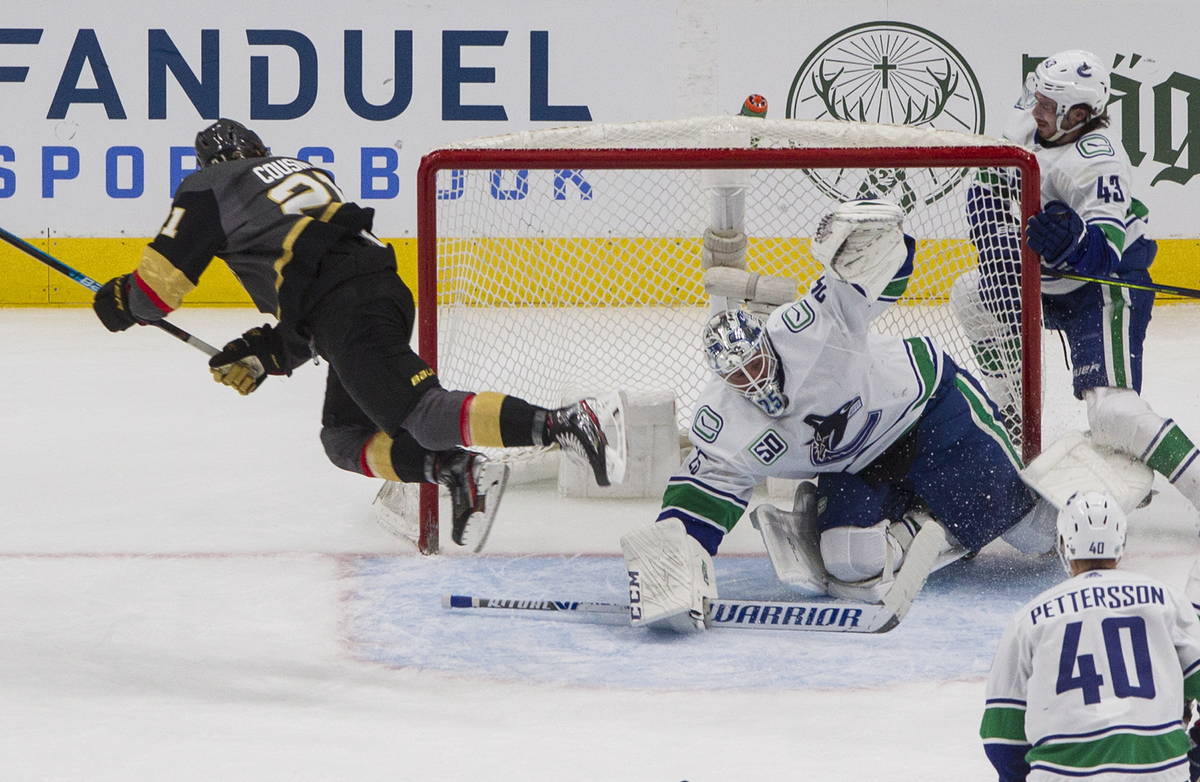 Vegas Golden Knights' Nick Cousins (21) jumps over Vancouver Canucks goalie Jacob Markstrom (25 ...
