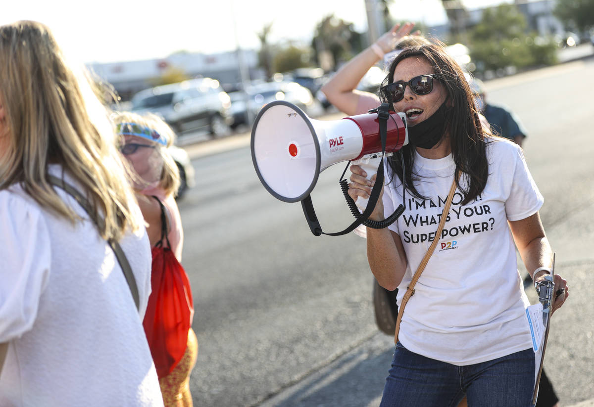Jillian Coons leads a chant during a demonstration in support of reopening public schools outsi ...