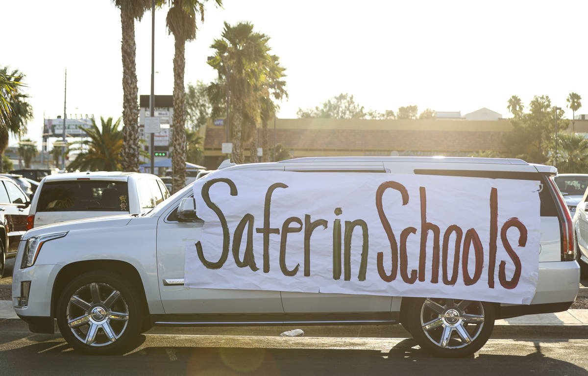 An SUV with a sign in support of reopening public schools outside of the Clark County School Di ...