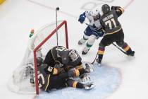 Vegas Golden Knights' Shea Theodore (27) crashes against goalie Robin Lehner (90) as Vancouver ...