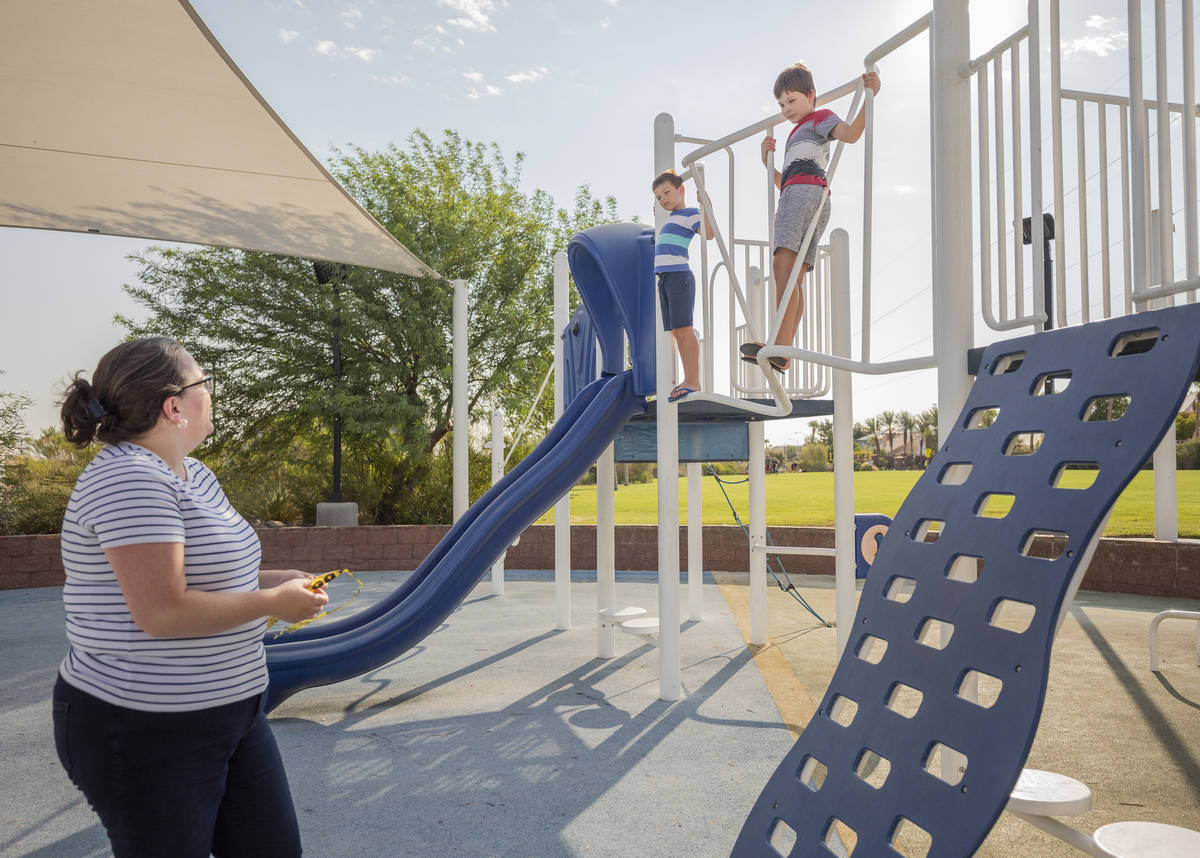 Janie Sandberg, left, watches her sons Carl, 7, left, and Robert, 10, play while she holds foun ...