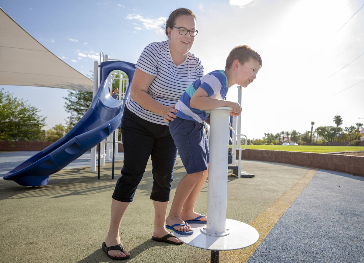 Janie Sandberg, left, holds her son Carl, 7, up as he plays at Siena Heights Trailhead Park in ...