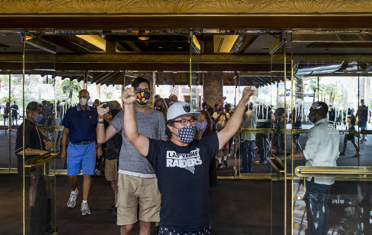 Kohei Munemura raises his arms in celebration as he and others enter the Mirage as it reopens o ...
