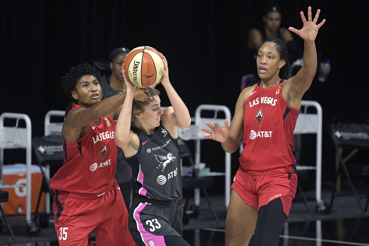 Dallas Wings guard Katie Lou Samuelson, center, is fouled by Las Vegas Aces forward Angel McCou ...