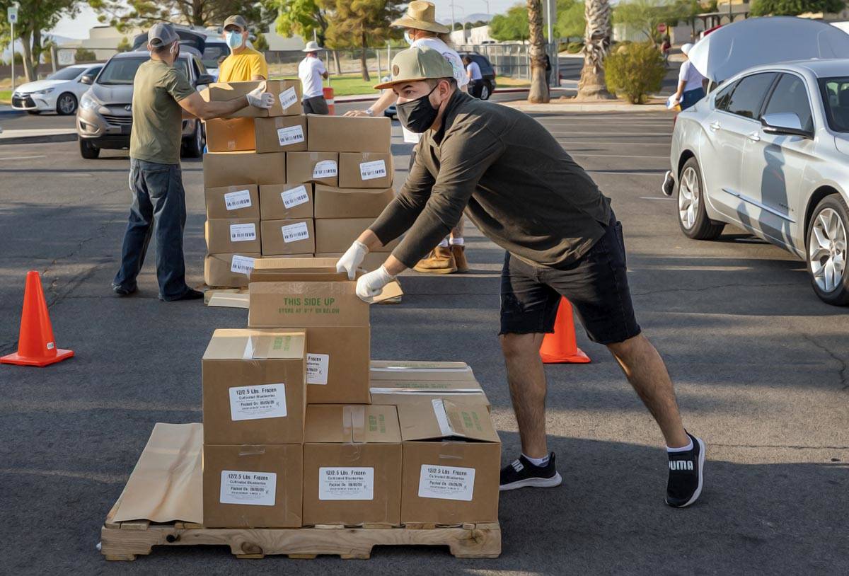 Miguel Landabazo, volunteer with Three Square Food Bank, distributes meals at Cannon Junior Hig ...