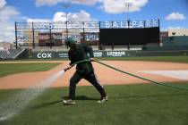 Groundskeeper Logan Mace sprays water on the field at the Las Vegas Ballpark in Las Vegas, Thur ...