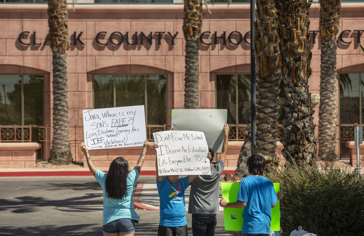 Parent and advocate Yesenia Gonzales, left, hold signs outside the Clark County School District ...