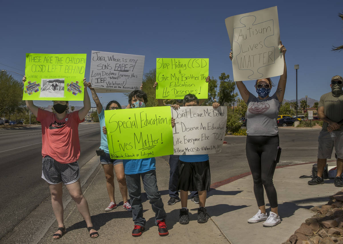 Parents and students stand on the sidewalk outside the County School District Administration Ce ...