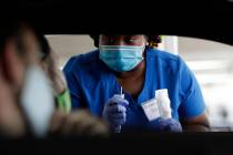 FILE - In this July 24, 2020, file photo, healthcare worker Rahaana Smith instructs passengers ...