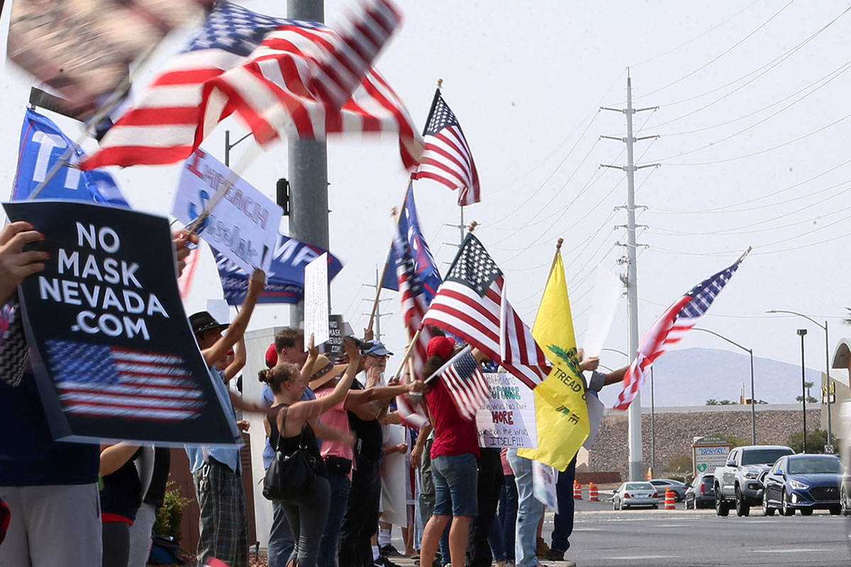 People attend a No Mask Nevada PAC rally at the intersection of Eastern Avenue and Pebble Road ...