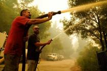 Civilian volunteers Brian Alvarez, left, and Nate Bramwell fight the CZU Lightning Complex Fire ...