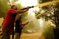 Civilian volunteers Brian Alvarez, left, and Nate Bramwell fight the CZU Lightning Complex Fire ...