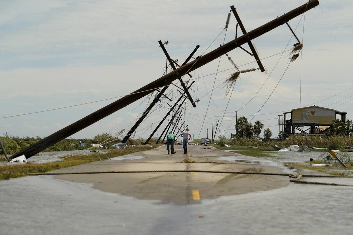 People survey the damage left in the wake of Hurricane Laura Thursday, Aug. 27, 2020, in Holly ...