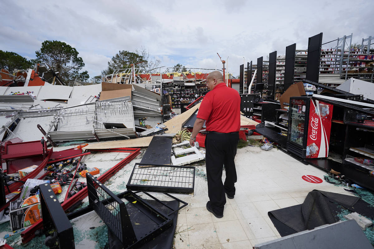 An auto parts store employee surveys the damage to the facilty on Thursday, Aug. 27, 2020, in L ...