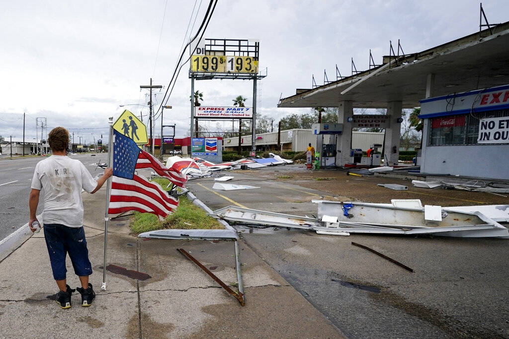 Dustin Amos walks near debris at a gas station on Thursday, Aug. 27, 2020, in Lake Charles, La. ...