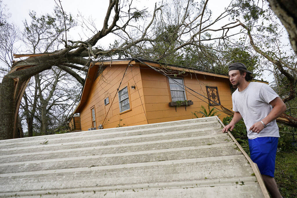 Brian McClendon sorts through debris at his home on Thursday, Aug. 27, 2020, in Lake Charles, L ...