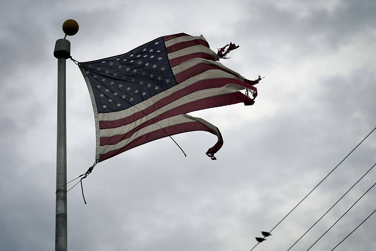 A tattered American flag blows in the wind in the aftermath of Hurricane Laura Thursday, Aug. 2 ...