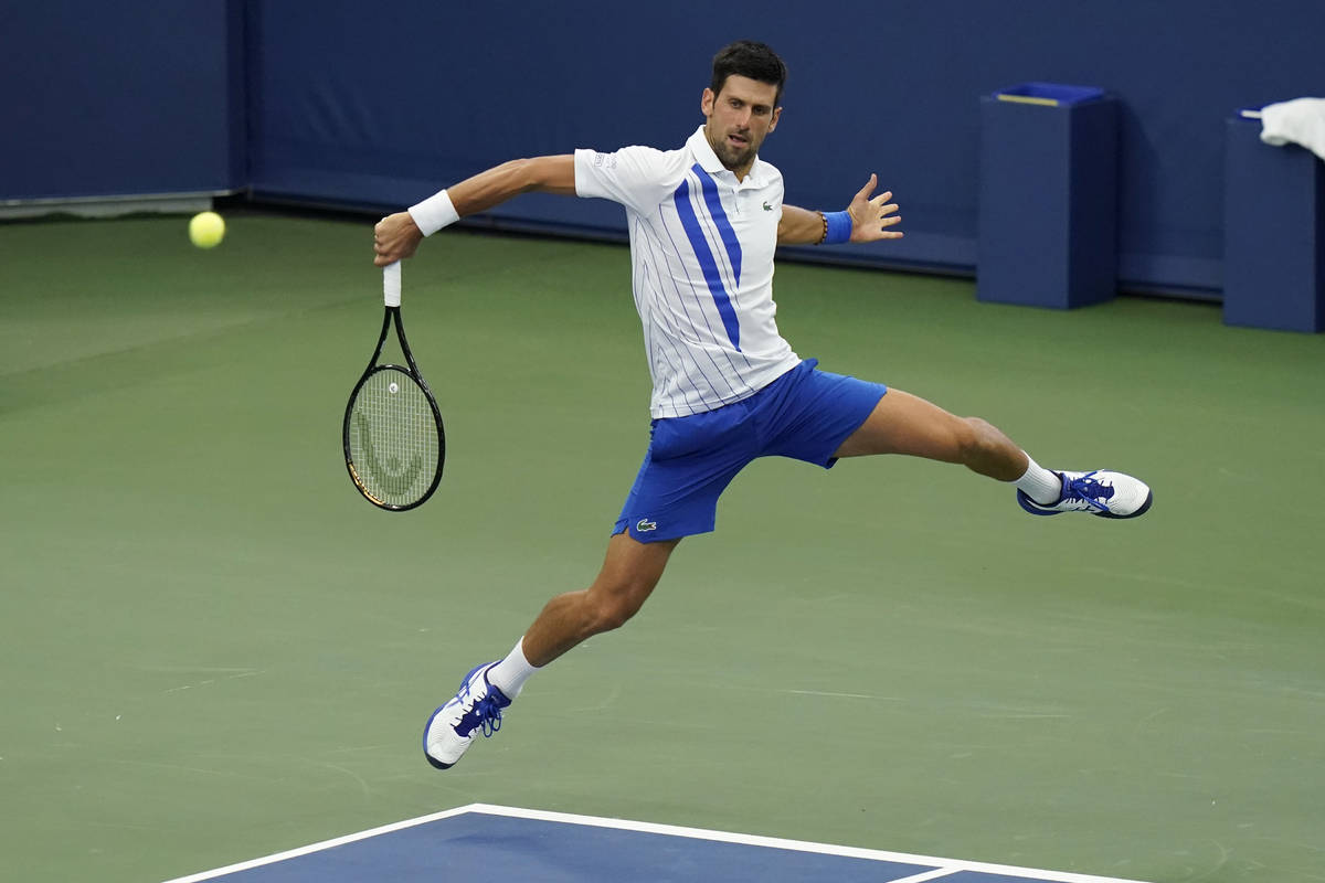 Novak Djokovic, of Serbia, returns a shot to Milos Raonic, of Canada, during the finals of the ...