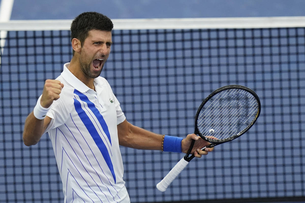 Novak Djokovic, of Serbia, reacts to winning his match with Milos Raonic, of Canada, during the ...