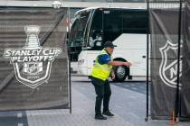 A security guard opens a gate for an empty player bus as it departs Scotiabank Arena in Toronto ...