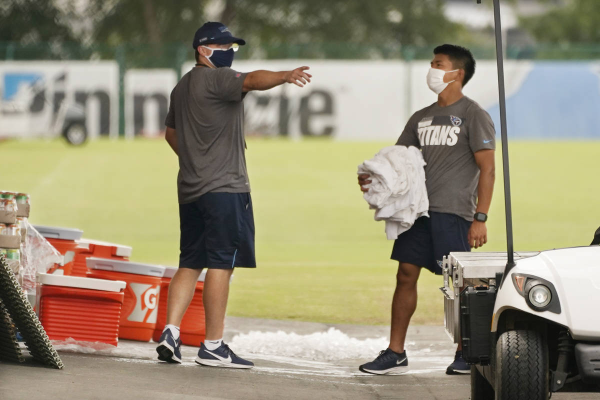 Tennessee Titans staff members remove items from the practice fields after practice was called ...
