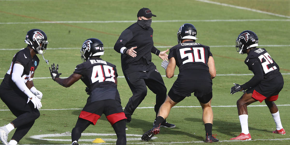 Atlanta Falcons head coach Dan Quinn, center rear, demonstrates a defensive drill during an NFL ...